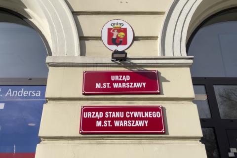 czerwone tablice informacyjne przy wejściu do urzędu