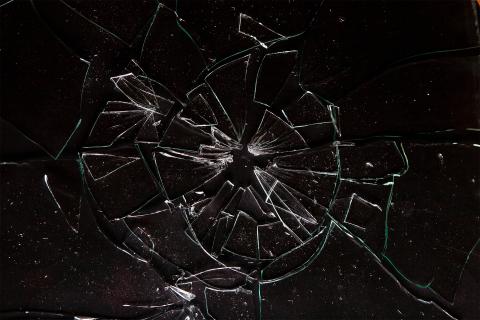 Stłuczona na kawałki szyba leży na płaskiej powierzchni