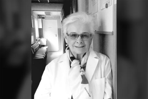 Portret dr. Moniki Madalińskiej - uśmiechnięta kobieta opierająca się o ścianę w korytarzu