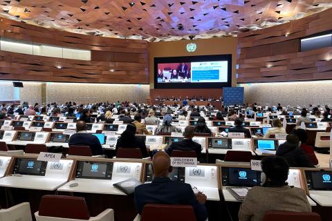 Kilkadziesiąt osób siedzi na dużej sali obrad