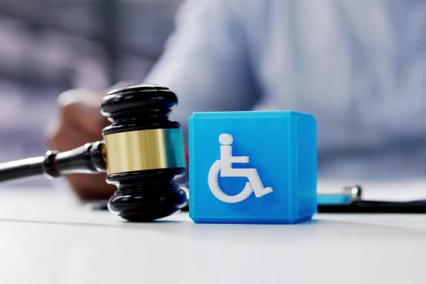 Kostka z symbolem osoby poruszającej się na wózku i młotek sędziowski