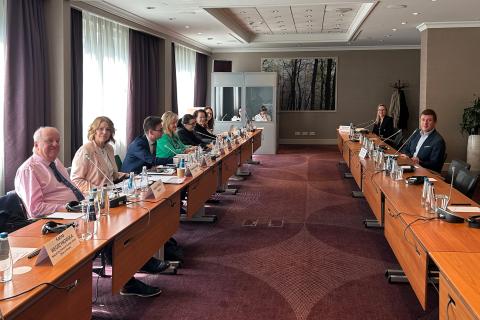 Sala, po której obu stronach ustawione są dwa długie stoły. Przy jednym siedzi siedem osób, przy drugim - dwie, w tym Wojciech Brzozowski. W szczycie sali znajduje się budka, w której siedzą dwie tłumaczki