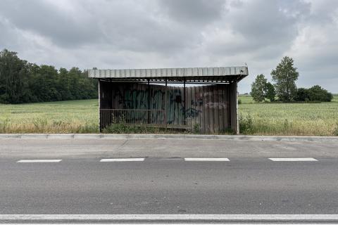 pusty dawny przystanek autobusowy w tle pole i las