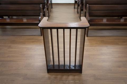 Podest dla świadka i biegłego na sali rozpraw. Za podestem znajdują się ławy dla publiczności. 