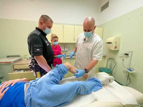 osoba leży na łóżku w gabinecie lekarskim trzy inne stoją   