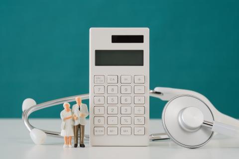 Ilustracja przedstawiająca kalkulator, stetoskop i dwie figurki starszych osób