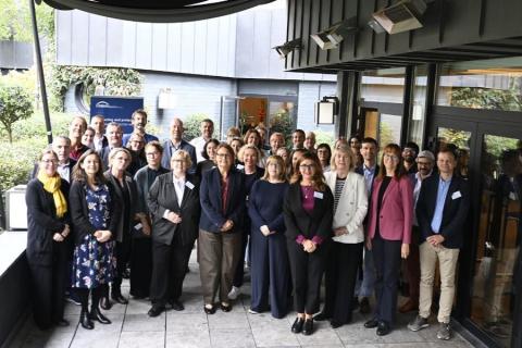 Kilkadziesiąt osób pozuje na stojąco do wspólnego zdjęcia