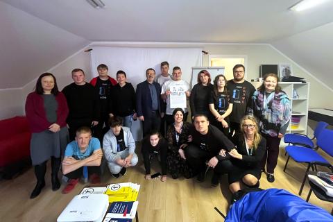 Kilkanaście osób pozuje do wspólnego zdjęcia