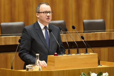 zdjęcie: mężczyzna w garniturze przemawia stojąc za mównicą