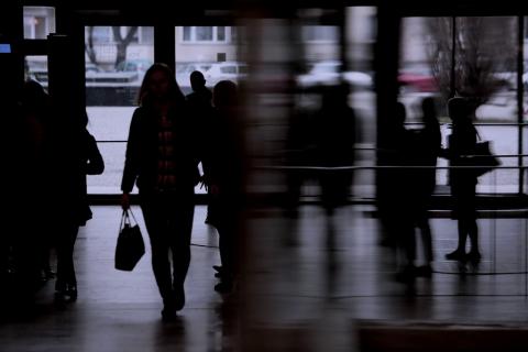 Niewyraźne sylwetki osób wchodzących do budynku