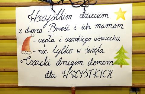 Plakat z napisem: Wszystkim dzieciom  z dworca Brześć i ich mamom – ciepła i szerokiego uśmiechu nie tylko w święta. Czacki drugim domem dla wszystkich