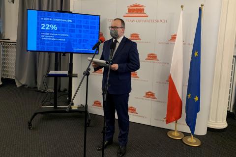 Mężczyzna w maseczce przed mikrofonem, na ekranie napis 22%