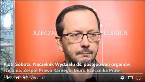 zdjęcie: mężczyzna w ujęciu poiersiowym na tle pomarańczowego baneru